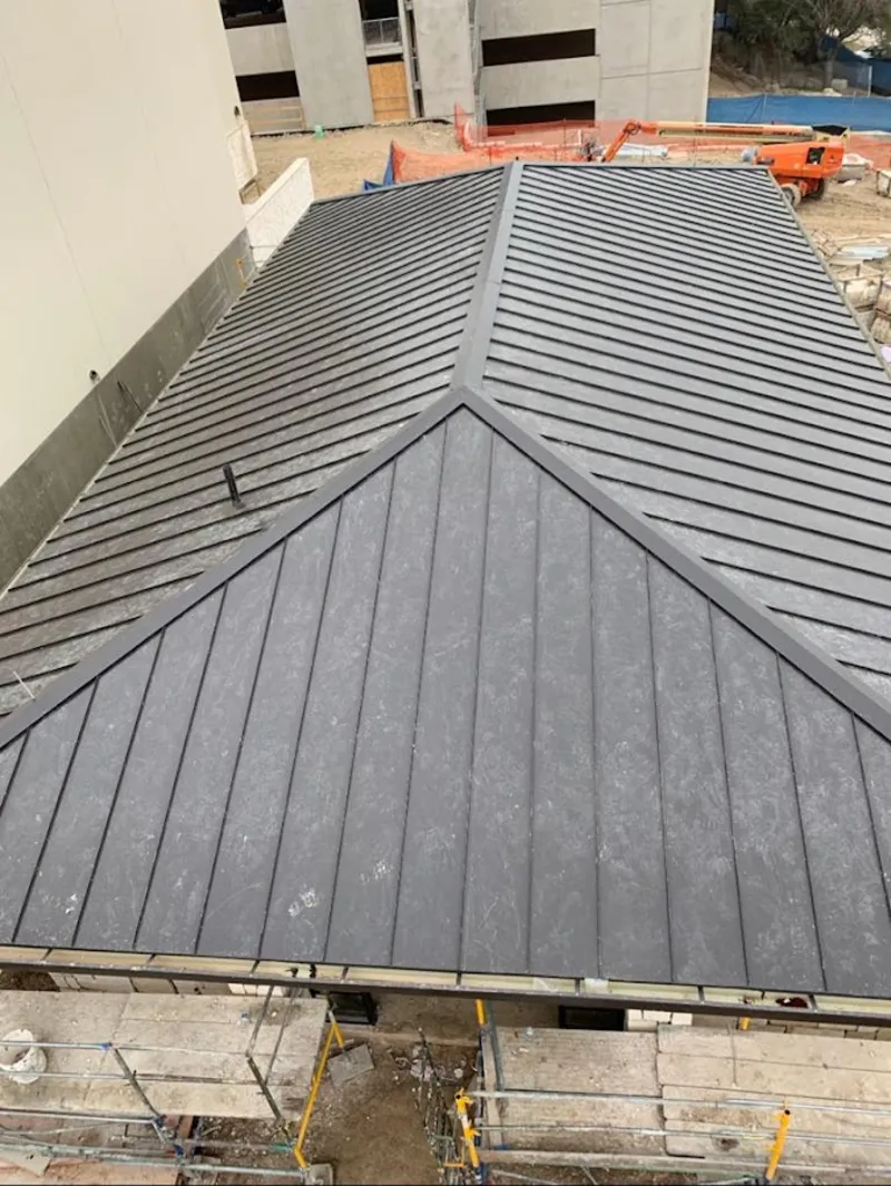 Commercial metal roof construction with crane equipment in Tuscumbia